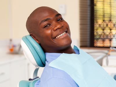 African American man smiling, perhaps after painless root canal treatment
