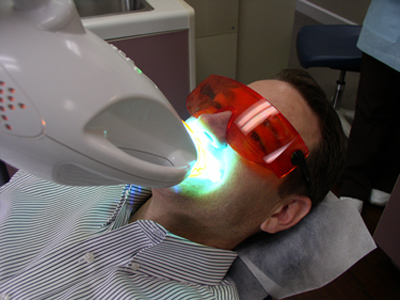 Man using the Zoom whitening light to activate the whitening gel.
