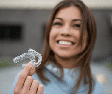 Woman Holding a Set of Clear Aligners