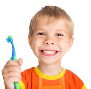 Boy smiling and holding a toothbrush
