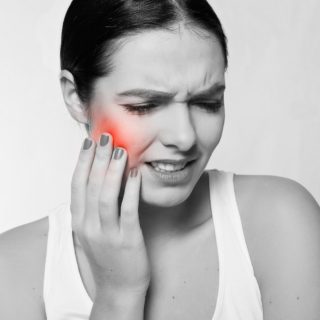Woman grabbing her jaw in pain