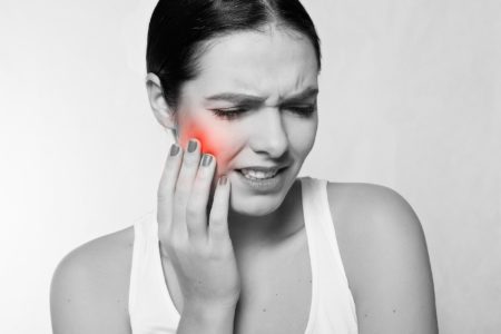 Woman grabbing her jaw in pain